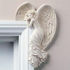 an angel figurine hanging on the side of a wall