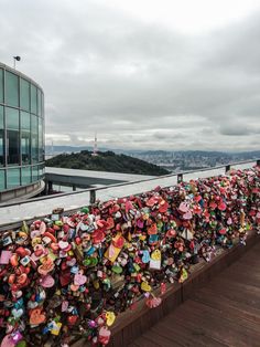 many padlocks are attached to the fence on top of a building with buildings in the background