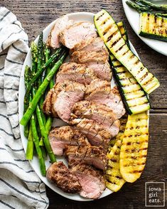 grilled pork with asparagus and pineapple slices on a white platter