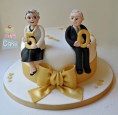 two figurines sitting on top of a cake with the number twenty five in front of them