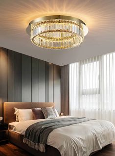 a bedroom with a large bed and a chandelier hanging from the ceiling above it