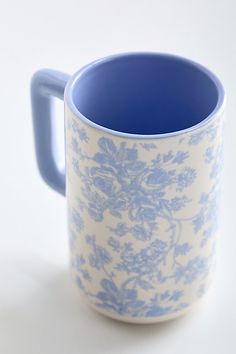 a blue and white coffee mug sitting on top of a table