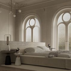 a large white bed sitting next to two tall windows in a room with high ceilings