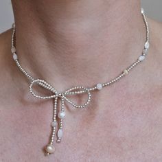 This dainty, elegant bow necklace is made of sterling silver beads and such natural stones as freshwater pearls, cat eye stones and mother-of-pearls stones. The beads are strung on an elastic jewelry cord, which give you an option  to wear the jewelry like a choker straight around your neck. Made of: - silver 925 1.8 mm round beads - freshwater pearls, cat eye stones and mother-of-pearl stones - silver 925 lobster closure + length adjustment (3 cm) - good quality jewelry cord, that keeps elasticity The position and combination of stones could slightly differ from picture, but in common the necklace will look the similar and at the same time will be unique) You can choose size from of the proposed or just write me a message with the size you need. You will receive a necklace packaged lovely Delicate Silver Beaded Necklace As Gift, Delicate Silver Beaded Necklace For Gift, Elegant Adjustable Pearl Necklace With Gemstone Beads, Elegant Adjustable Sterling Silver Beaded Necklaces, Elegant Sterling Silver Beaded Necklace, Delicate Adjustable Silver Pearl Necklace, Elegant Sterling Silver Pearl Necklace With Gemstone Beads, Dainty Pearl Beaded Necklaces In Silver, Dainty Silver Pearl Beaded Necklaces