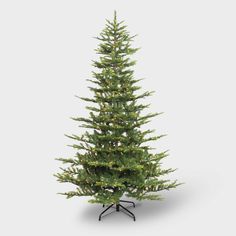 a small christmas tree on a stand with lights in the top and bottom branches, against a white background