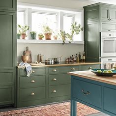 a kitchen with green cabinets and an island