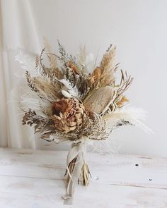 a bouquet of dried flowers on a white table