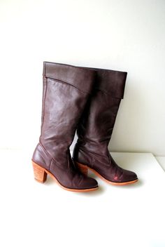 "Boho vintage 70s dark brown with a hint of burgundy, genuine leather boots. Made by Dexter in USA. Pirate style cuffed top. Chunky stocked wood heel. Lined with a brown nylon. Gently used condition. The high quality leather is clean, soft and strong. Little distressed from the front sides. But it's don't effected a value. No odor. Size 5 1/2 m. Tall ( of the back) with a heel:15,0\" Size of the heel:2,5\"x1,5\" Width of the cup up front:3,0\" Width of the opening:14,0\" Length of the insole:7,0 Brown Boots With Wooden Heel For Fall, Vintage Leather Heeled Boots With Stacked Heel, Vintage Brown Heeled Boots With Stacked Heel, Vintage Brown Wide Calf Boots, Brown Vintage Wide Calf Boots, Vintage Brown Heeled Boots For Winter, Retro Brown Heeled Boots For Winter, Pirate Style, Pirate Fashion