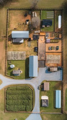 an aerial view of a farm with lots of grass and buildings in the middle of it