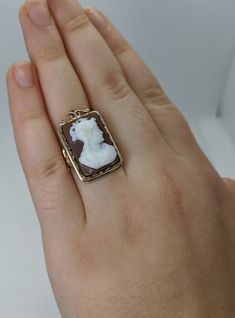 This gorgeous vintage cameo ring is beautifully crafted in a solid 14k gold frame with details at every angle. The victorian style is likely a 1930-1950s creation. In the center is a carved shell cameo of a Roman soldier. The cameo is in excellent condition and the sturdy ring measures approximately 26.45mm tall (including gold filigree fame) x 17.37mm wide. The ring is currently a ring size 7.5 but can be resized by your trusted local jeweler. A bold statement ring for men and women who love an Roman Soldier, Wedding Rings Photos, Victorian Revival, Beaded Evening Bags, Cameo Ring, Vintage Cameo, Carved Shell, Ring For Men, Gold Filigree