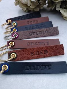 four personalized leather key chains with name tags on them, one for dad and the other for daddy