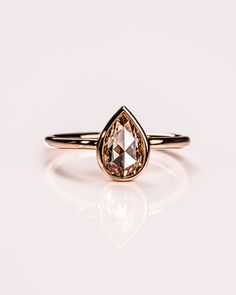 a gold ring with a brown diamond on it