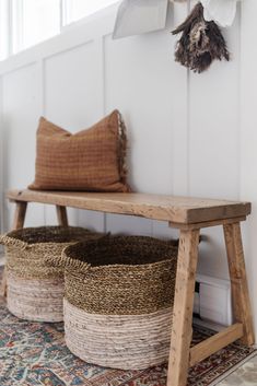 two baskets sitting on top of a wooden bench