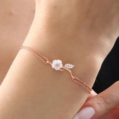 The magnolia-like flower on the bracelet is made of original mother-of-pearl stone. The mother-of-pearl stone represents power, grace and abundance. In addition, proximity to the mother-of-pearl stone has many benefits in energy. The two-stranded bracelet design that combines mother-of-pearl stone with the bracelet represents the journey of life and the elegance of women. It has a design that you will always carry with you in your daily life, on an important date, on the beach or at a great part Delicate Rose Gold Flower Jewelry, Dainty Rose Gold Flower-shaped Bracelets, Dainty Rose Gold Flower Bracelets, Dainty Rose Gold Bracelet With Flower Charm, Rose Gold Flower-shaped Bracelets As Gifts, Rose Gold Flower Shaped Bracelets For Gifts, Rose Gold Flower-shaped Bracelets For Gifts, Dainty Sterling Silver Bracelet With Flower Charm, Dainty Rose Gold Flower Jewelry