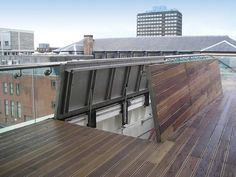 an open window on the side of a building with wooden flooring and roof top