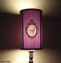 a lamp that has a skull on it with a red and white striped lampshade