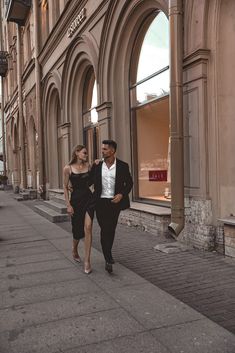 a man and woman are walking down the street