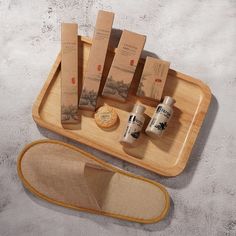 a wooden tray with four bottles and two pairs of shoes