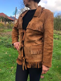 Vintage 90s leather fringe jacket. Brown suede leather with fringes. Hippie, Boho jacket. Not lined. Two front pockets. VANDEM label. Tie closure. Marked as size 48. Defect on the back side from the inside (see on last photo) To fit size S/M From shoulder to shoulder 18" 46cm Bust 38" 97cm Sleeve length 22" 56cm + 1" (see on photo) Length 26,5" + 2,5" 7cm fringe length Winter Leather Outerwear With Tassels, Winter Leather Tassel Outerwear, Bohemian Leather Outerwear For Winter, Bohemian Brown Leather Jacket For Winter, Bohemian Leather Winter Outerwear, Brown Fringe Outerwear For Winter, Bohemian Winter Leather Jacket With Fringe, Vintage Leather Jacket With Fringe For Winter, Vintage Fringe Leather Jacket For Winter