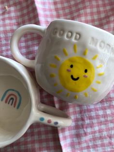 two mugs sitting next to each other on a pink and white checkered table cloth