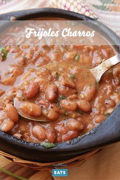 a skillet filled with beans on top of a wooden table