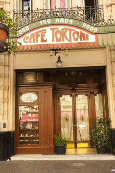 the front entrance to cafe tortoni in paris, france with potted plants