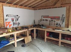 a garage with work benches and tools on the wall