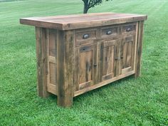 a wooden cabinet sitting on top of a lush green field