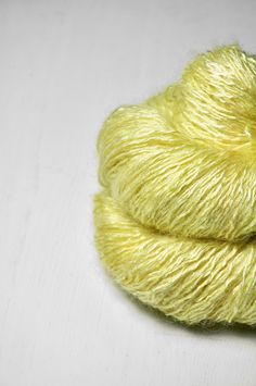 a skein of yellow yarn sitting on top of a white table