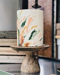 a white cake sitting on top of a wooden stand