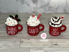 three red mugs filled with hot chocolate and whipped cream