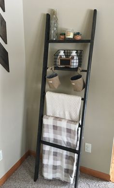 a bathroom with a ladder leaning against the wall next to towels and other items on it