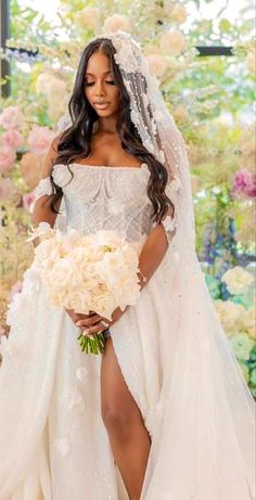 a woman in a wedding dress with flowers on the side and her legs crossed, holding a bridal bouquet