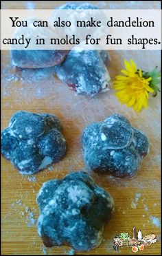 four blue donuts sitting on top of a wooden table next to a yellow flower