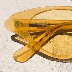 a pair of yellow glasses sitting on top of a white table next to a mirror