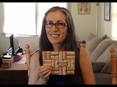 a woman sitting on a couch holding up a piece of cork that looks like a maze