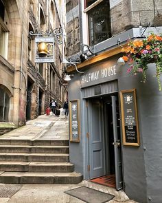 the entrance to halfway house with flowers hanging from it's door and stairs leading up