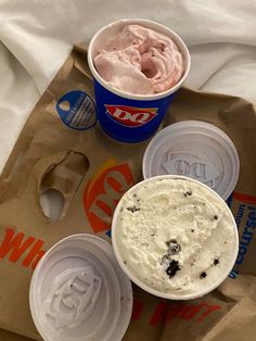 two cups of ice cream sitting on top of a bag