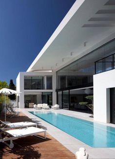 an empty swimming pool in front of a modern house