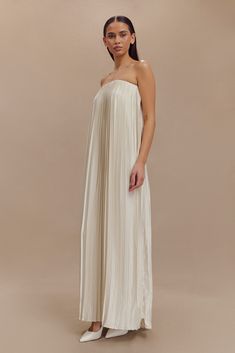 Pleated luxury. The MYRAH Plisse Strapless Maxi Dress is a glamorous and versatile choice for making a stylish statement. Designed with a strapless neckline and an open back featuring elastic strap detail, it combines modern elegance with a touch of allure. The elastic top edge ensures a secure fit, while the pleated satin fabrication adds a luxurious sheen and fluid movement. The straight, relaxed shape offers effortless sophistication, and the front leg split adds a hint of drama and ease of movement. Perfect for formal events or special occasions, the Myrah Dress embodies both chic style and comfort. Capsule Wardrobe Accessories, Capsule Wardrobe Basics, Fluid Movement, European Summer Outfits, Leg Split, Elastic Top, Wardrobe Accessories, Maxi Dress Sale, Strapless Neckline