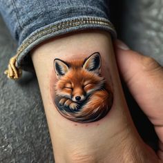 a small fox tattoo on the wrist