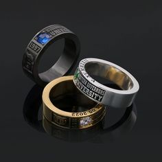 two rings with different designs on them sitting next to each other in front of a black background