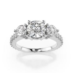 This beautiful round cut engagement ring features a 3 stone design featuring two 0.25 carat side stones and a dazzling array of accent stones throughout. The accent stones total approximately 1.01 ctw. Optional matching curved band is available. 1.00 carat center stone shown. This ring is made to order. Please select your options and allow 2-3 weeks for delivery. Round Cut Engagement Ring, Wedding Day Jewelry, Round Cut Engagement Rings, Engagement Rings Platinum, Diamond Guide, Bespoke Jewellery, Womens Wedding Bands, Stone Design, Fine Jewellery Earrings