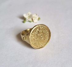 Beautiful solid gold old coin signet ring, vintage-style big round boho jewelry for women, available in 9k or 14k yellow gold.  This handmade gold ring is made by minting a beautiful Swiss coin decorated with flowers and attaching it to a solid gold band. The band features three small dots on each side, adding a unique, vintage character to this jewelry piece. It is available in 9k or 14k solid yellow gold.  This statement ring is exquisite and delicate, with a charmingly romantic and vintage to Vintage Coin Signet Ring As Gift, Vintage Coin Shaped Signet Ring Gift, Vintage Coin Signet Ring For Gift, Vintage Engraved Coin Signet Ring, Antique Coin-shape Engraved Signet Ring, Antique Coin Shaped Engraved Signet Ring, Antique Engraved Coin Signet Ring, Vintage 14k Gold Coin Ring, Gold Coin-shaped Engraved Signet Ring