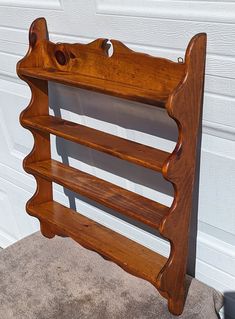 a wooden shelf sitting in front of a garage door