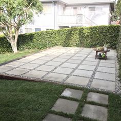 an outdoor patio area with grass and stepping stones