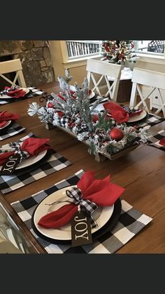 the table is set with black and white checkered placemats, red napkins, silver pine cones, and evergreen branches