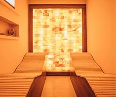 an empty room with several beds in front of a glass block wall that is reflecting light