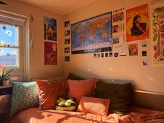 a bed sitting under a window covered in posters