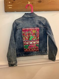 Mini Indie embroidered denim jackets are handmade by Esme in Manchester UK.  Size U.K. 7-8 years  Stone washed denim jacket with two front pouch pockets and button opening. Embroidered back with beautiful woven Indian braid.  EsmeAndTheEye upcycles second-hand denim jackets and gives them a new lease of life by adding beautiful Indian braid and embroidered textiles.  Each piece is hand picked by Esme and loving re-worked to create a hippie unique jacket. Esme designs each piece unique so you wil Embroidered Denim Outerwear For Festival, Multicolor Denim Jacket For Festivals, Bohemian Denim Jacket With Patches, Bohemian Cotton Denim Jacket With Patches, Bohemian Embroidered Denim Jacket For Fall, Festival Multicolor Denim Jacket, Bohemian Denim Jacket With Multicolor Embroidery, Bohemian Denim Outerwear With Multicolor Embroidery, Bohemian Denim Jacket With Floral Embroidery For Fall